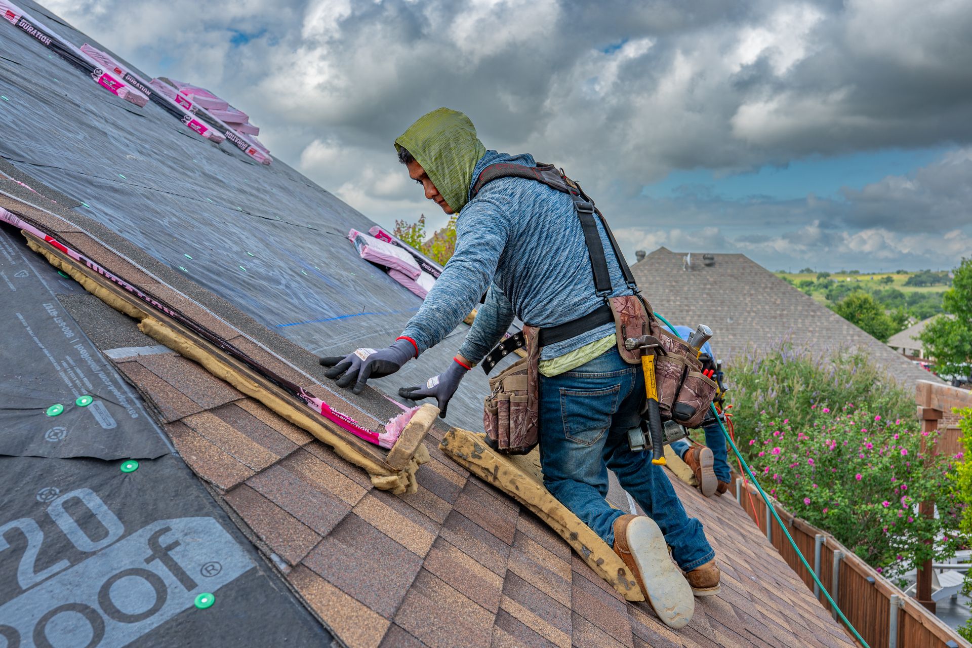 Roofer installing shingles on a residential roof